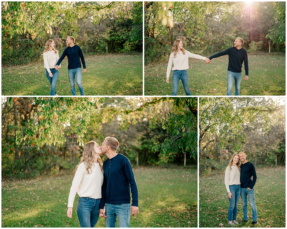 engaged couple smiles as they hold hands on grassy lawn by Minnesota Wedding Photographer