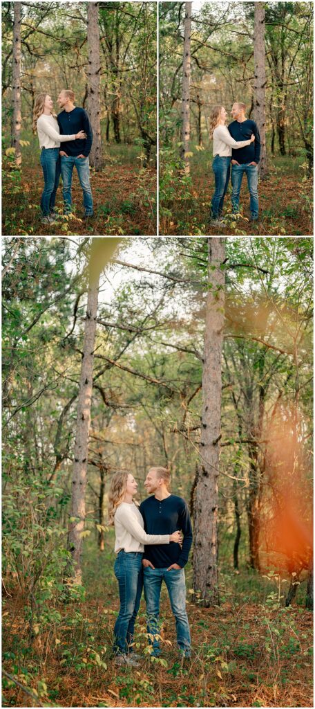 woman hugs man in woods by Minnesota engagement photographer