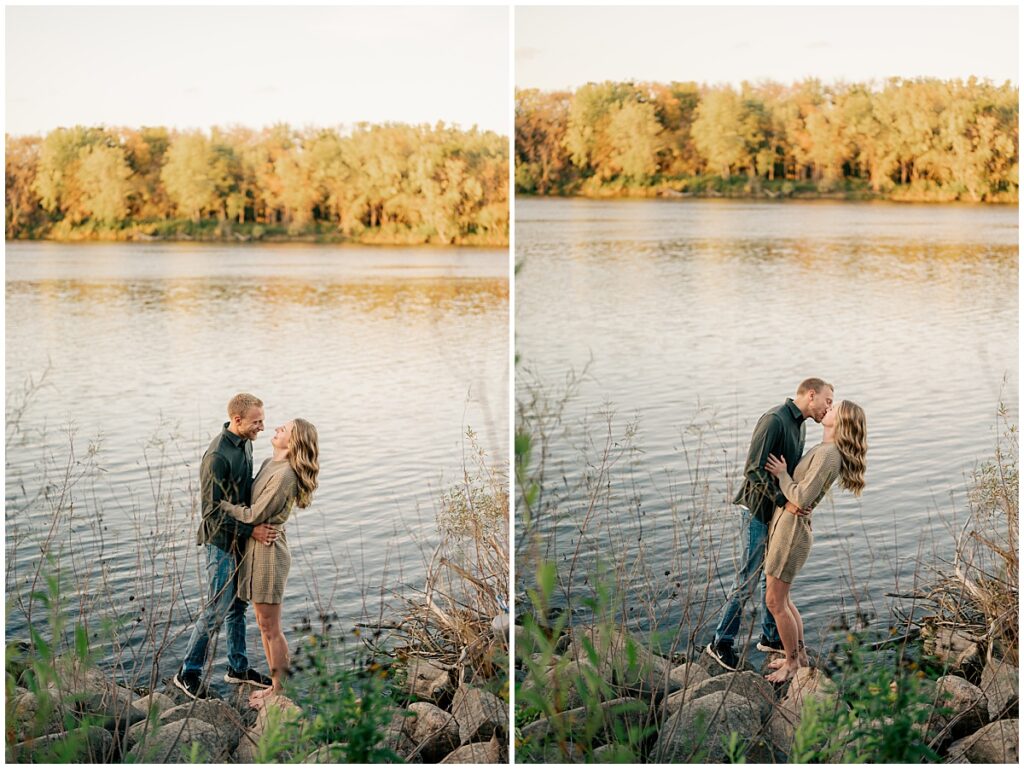 man kisses woman by lake by Minnesota engagement photographer