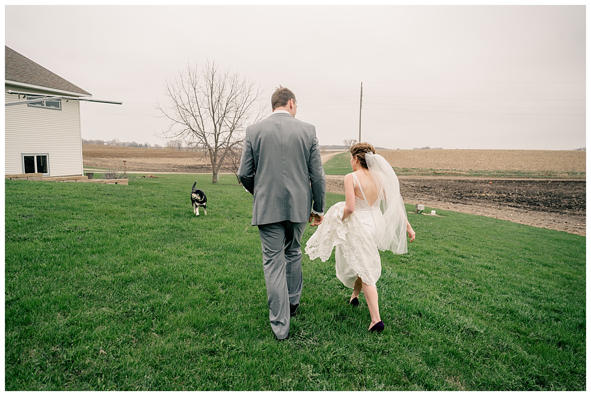 newlyweds walk together on lawn with pup by Rule Creative Co