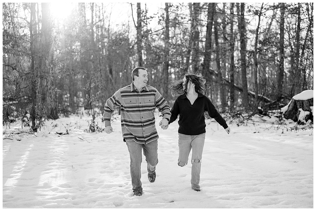 couple runs through snow looking at each other by Minnesota wedding photographer