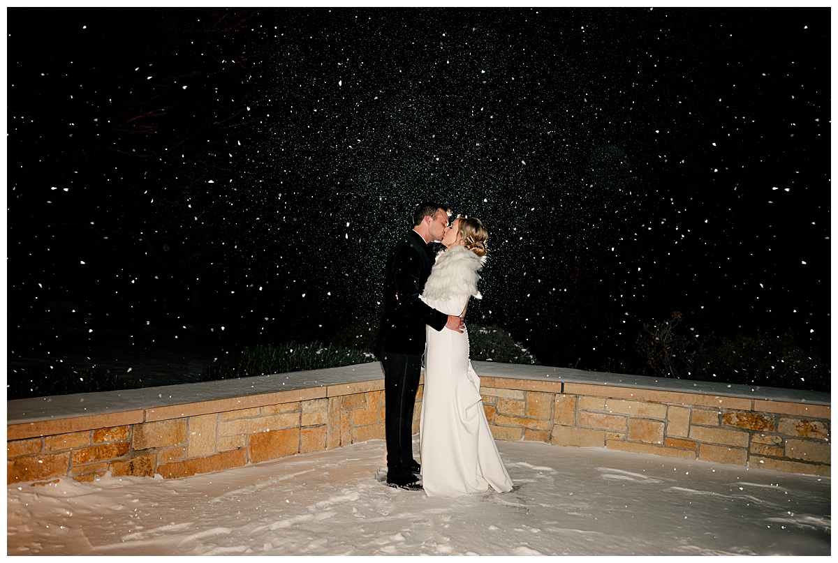 couple kisses in snow while keeping a relaxed wedding timeline