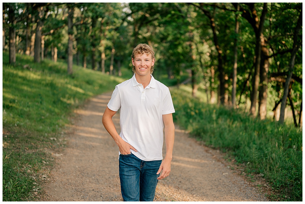 teen walks with hand in pocket along path by Minnesota photographer