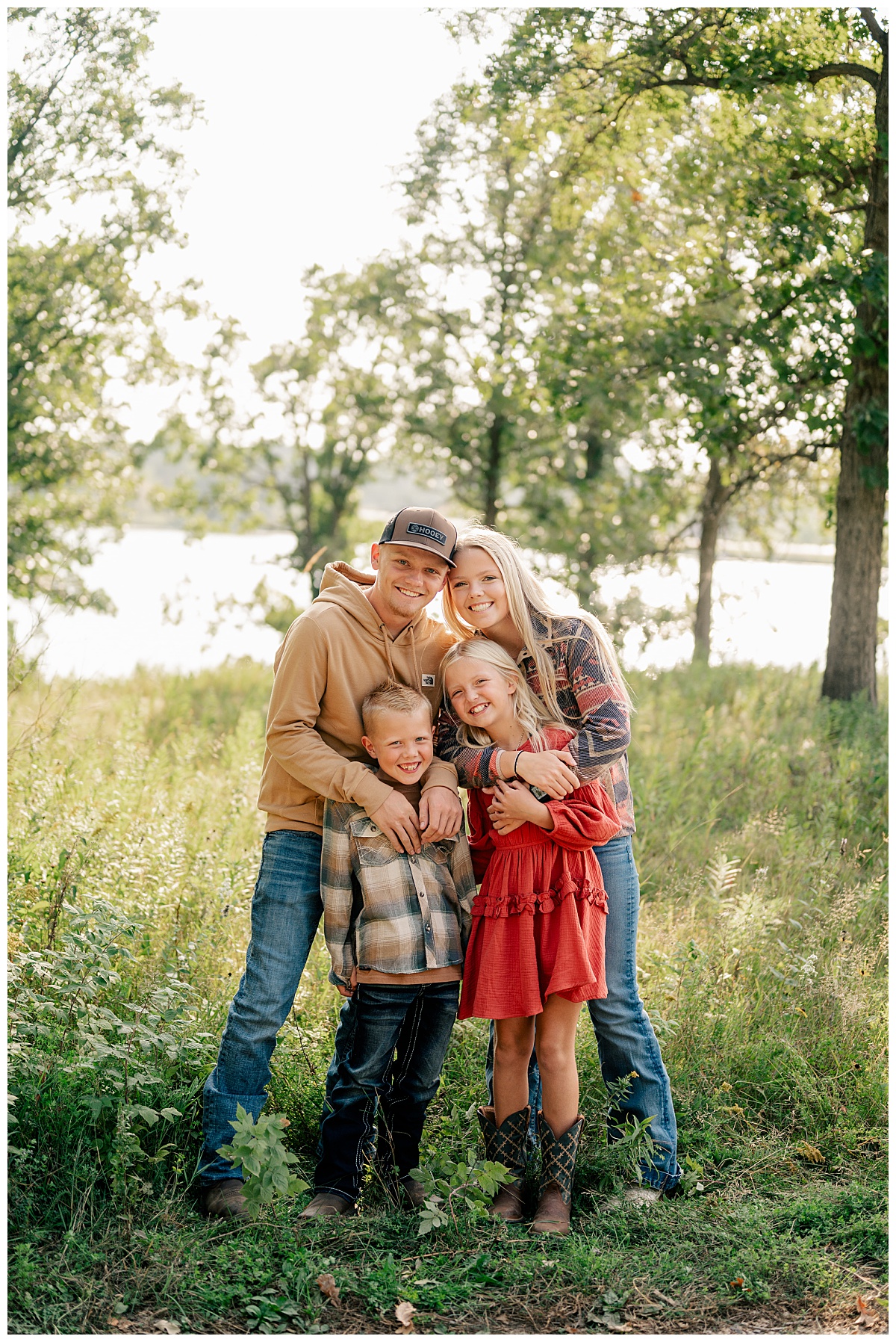 siblings lean together in meadow during summer mini sessions
