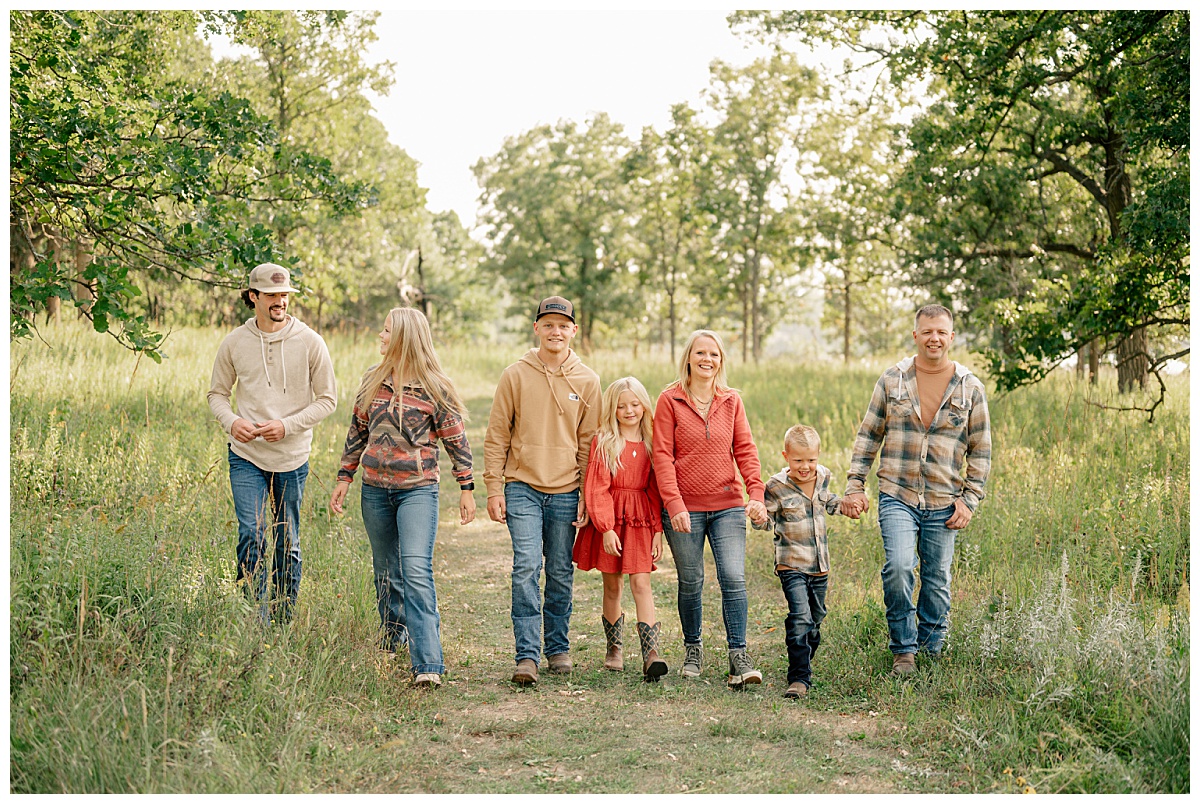 family walks shoulder to shoulder at park by Minnesota photographer