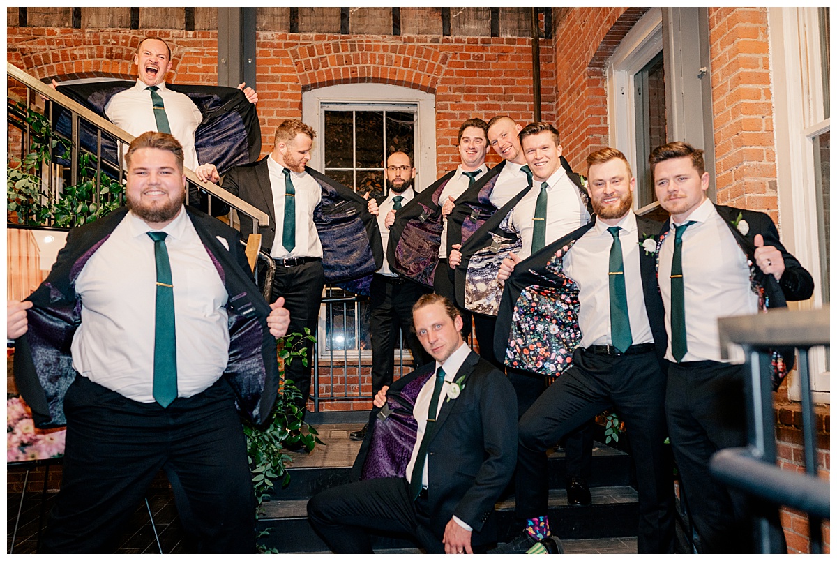 groomsmen show off the inside of their suit coats by Minnesota wedding photographer