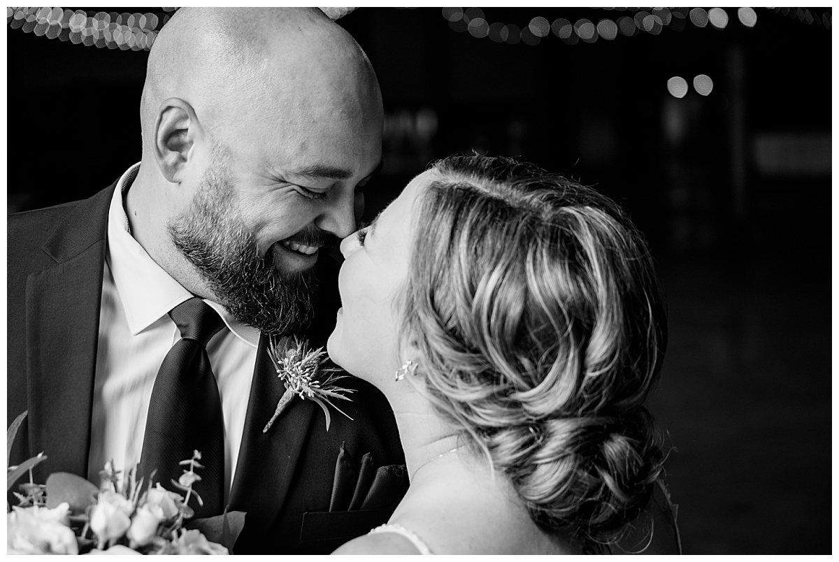 bride and groom touch noses as they smile at each other by Rule Creative Co