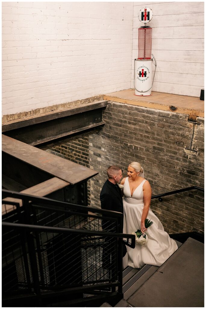 couple looks at each other in the stairwell after their ceremony by Minnesota wedding photographer