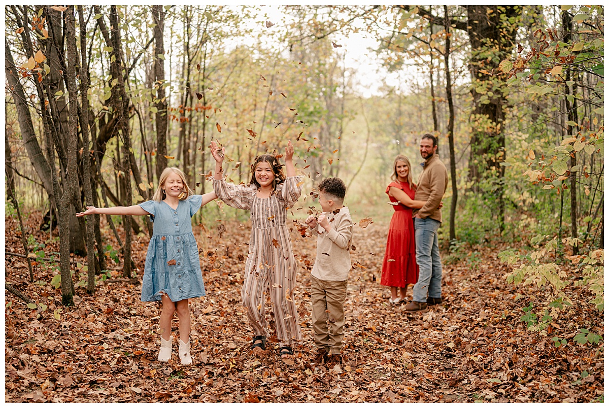 kids throw leaves in the air during fall mini sessions