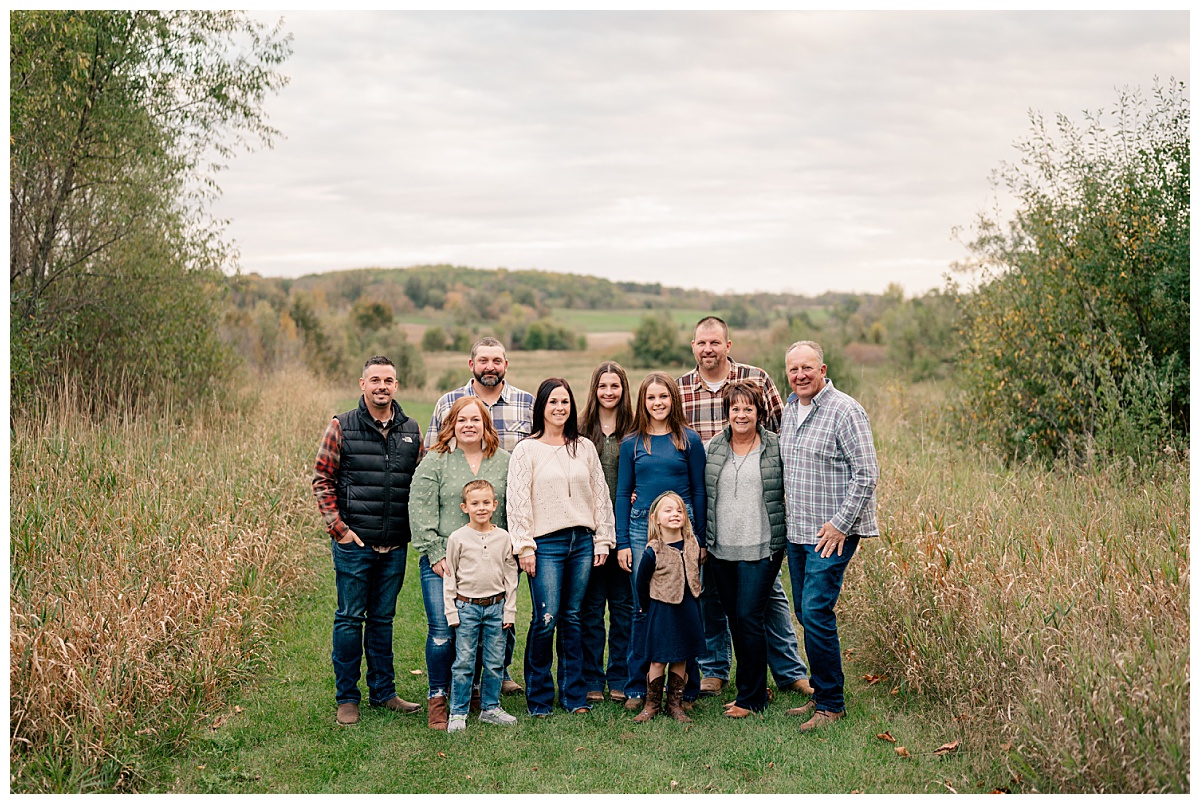 extended family gathers together in meadow by Minnesota photographer