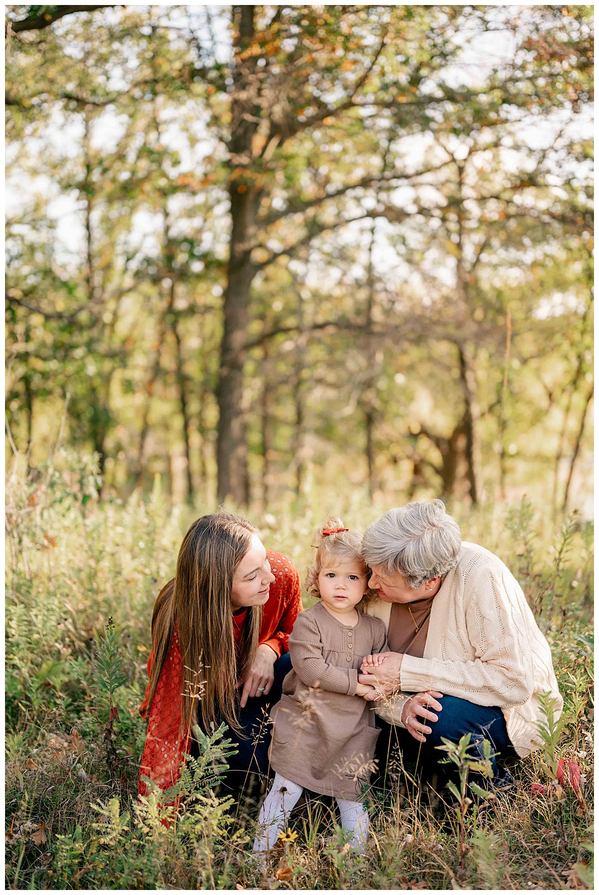 mom and grandma look at toddler smiling by Minnesota photographer