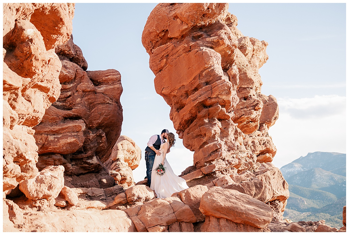 couple kisses at Colorado's red rocks at photographer's favorite engagement & elopement session destinations