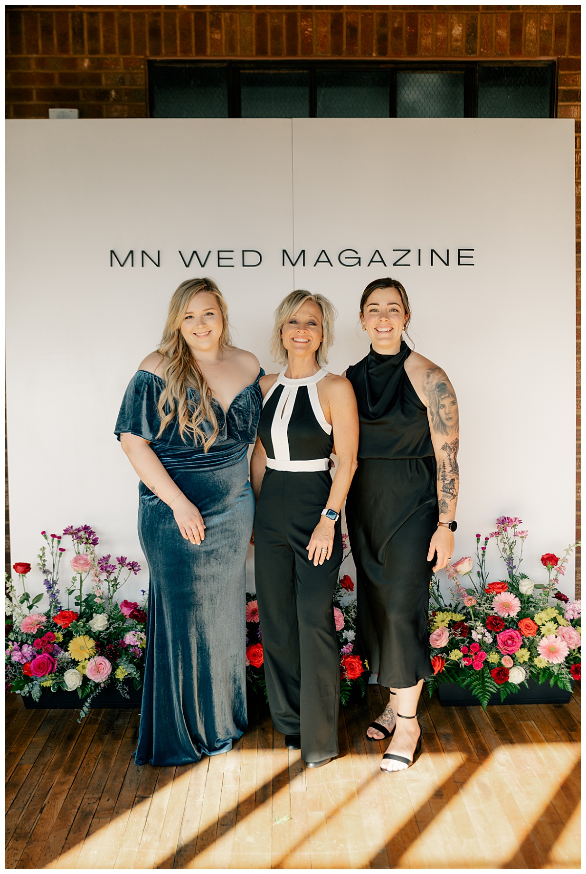creative team behind MN Wed Magazine in front of step and repeat by Rule Creative Co