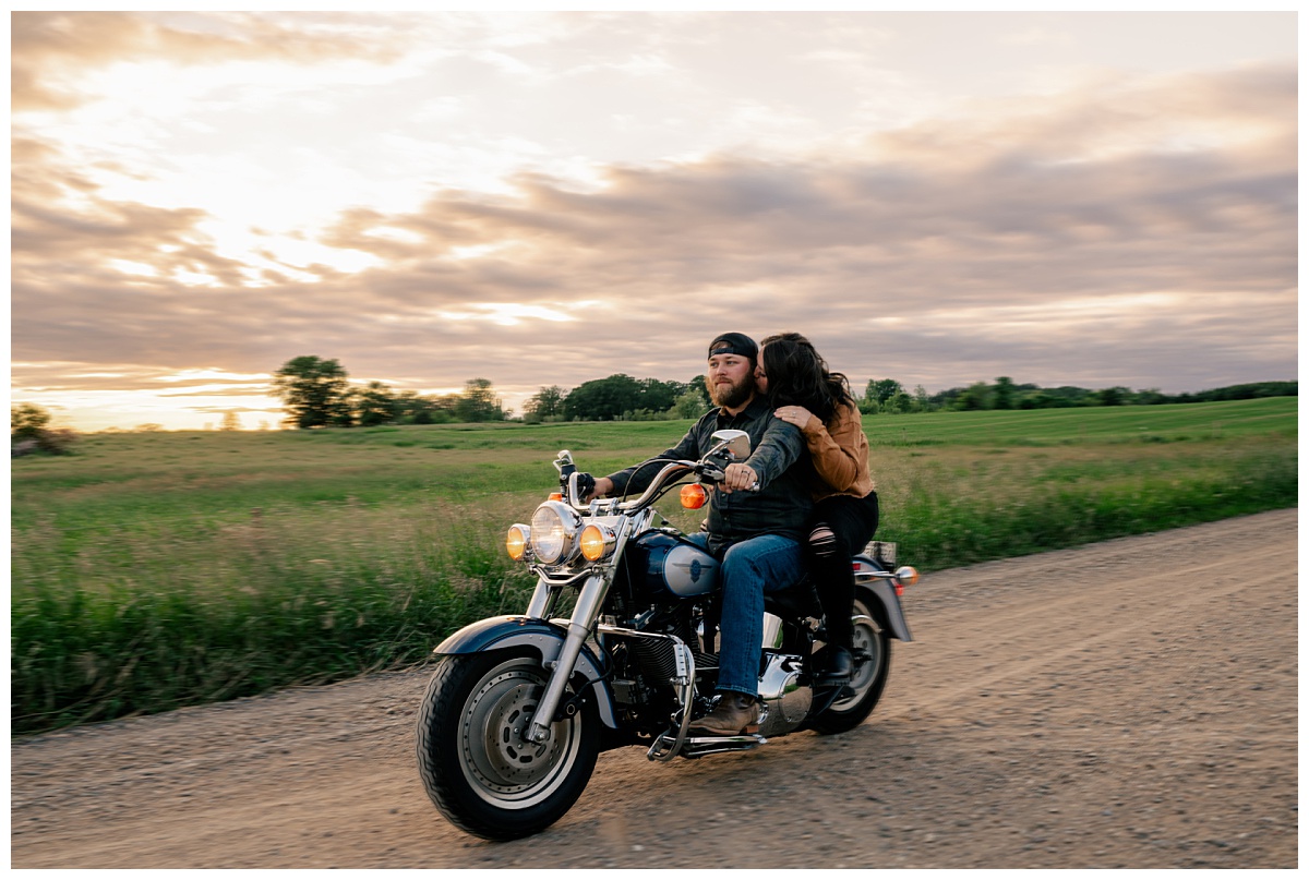 woman kisses man as they ride on motorcycle by Minnesota photographer