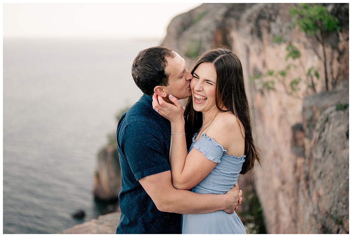 man kisses woman's cheek as she laughs by Rule Creative Co