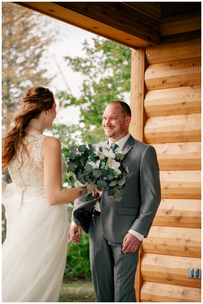 groom looks at bride before ceremony by Minnesota wedding photographer