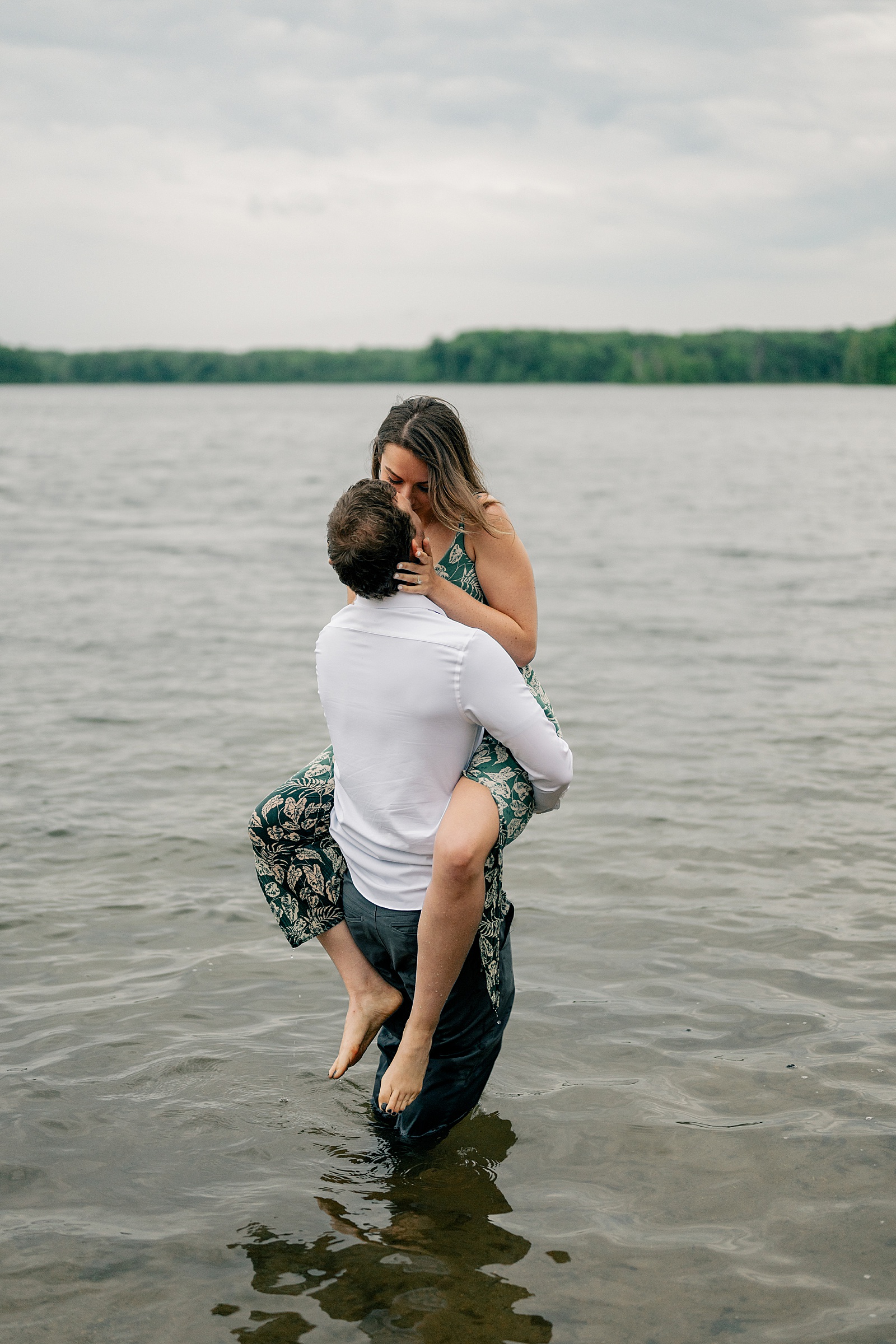 woman straddles man to kiss him in the water by Rule Creative Co