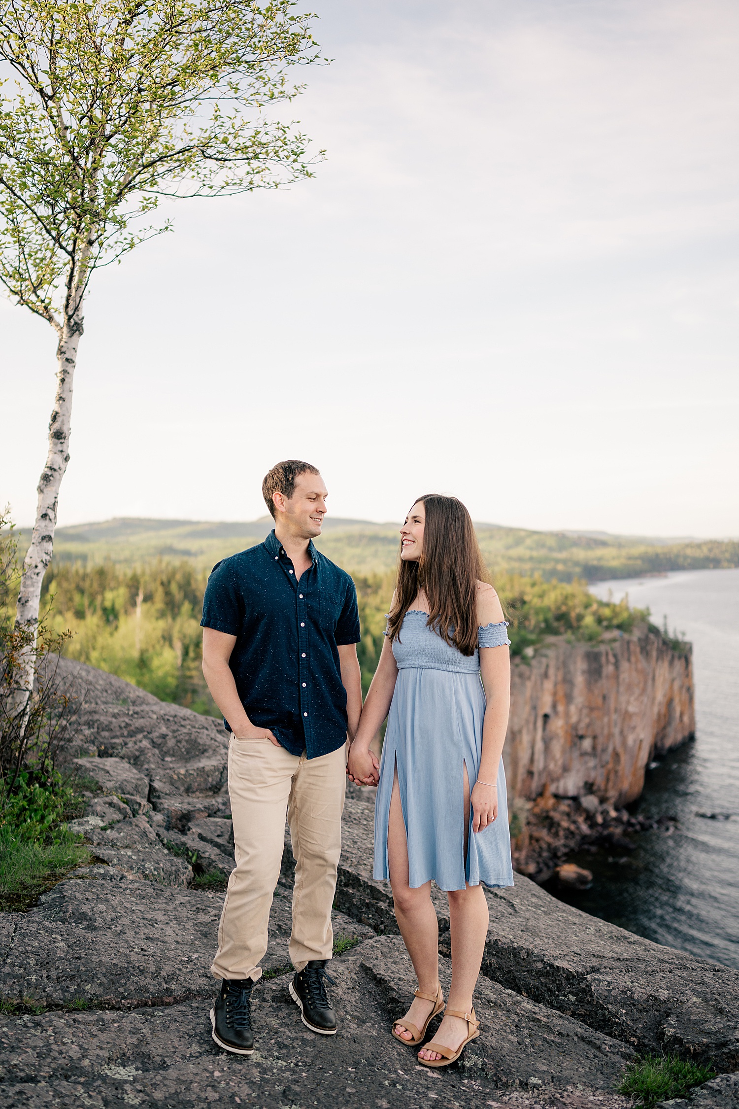 brunette smiles up at fiancé during golden hour at North Shores