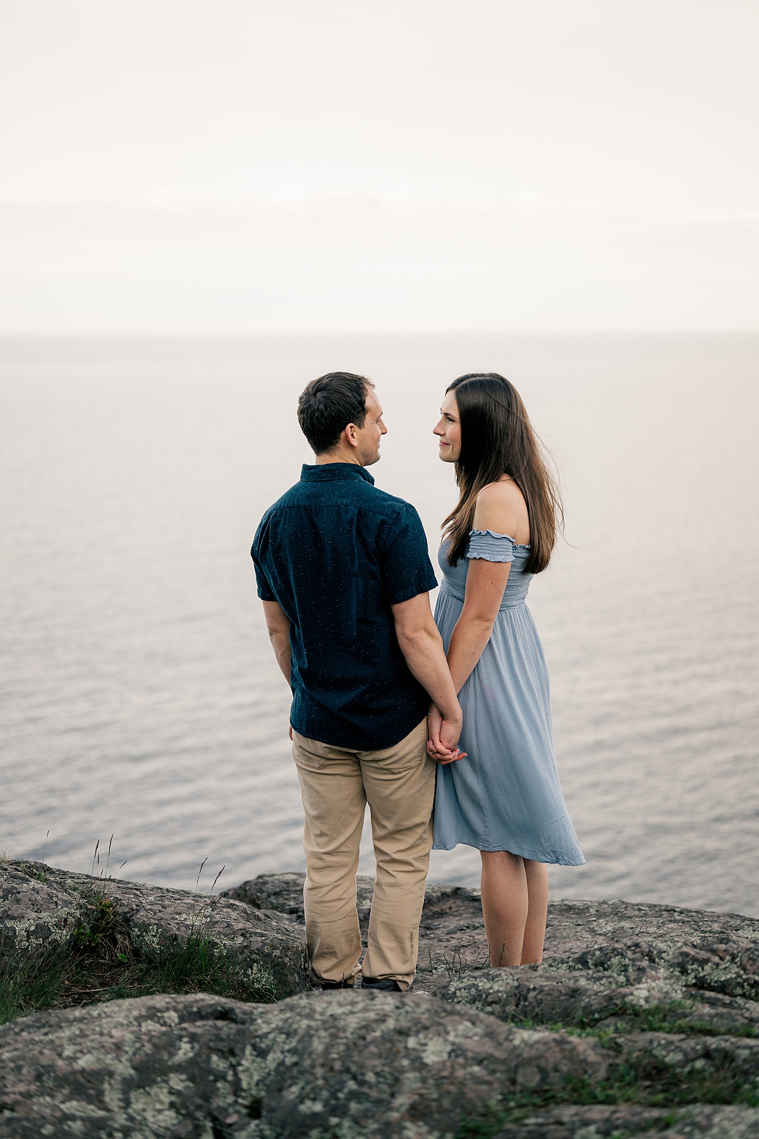 woman in blue off the shoulder dress smiles at man by Minnesota wedding photographer