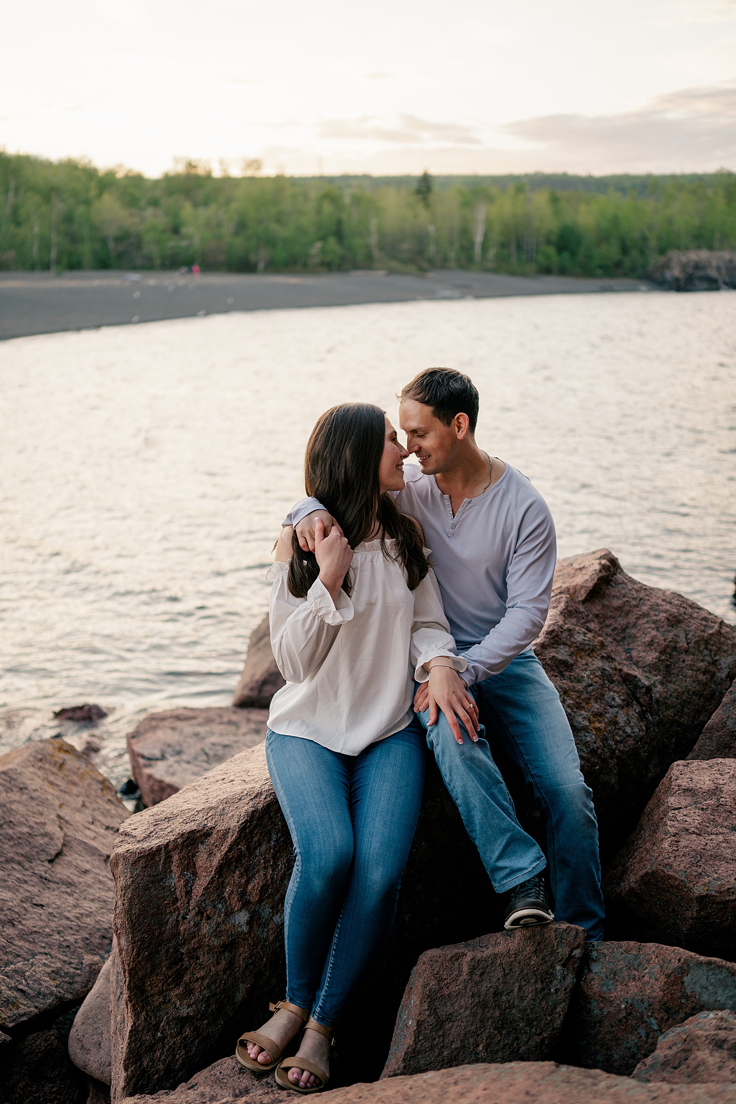 man hugs wife-to-be close on the rocks by Rule Creative Co