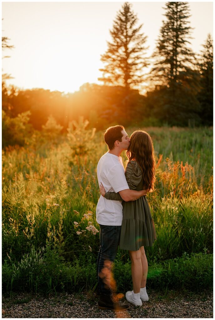 man kisses woman on cheek during golden hour St. John's engagement 