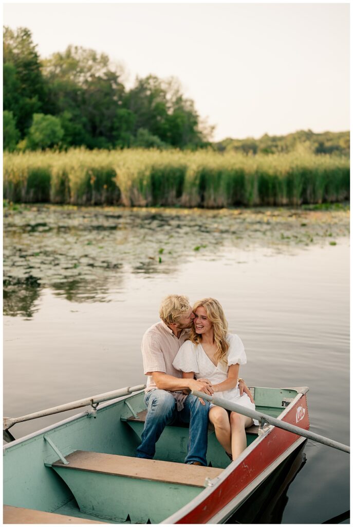 man kisses fiance on the cheek while in a boat by Rule Creative Co