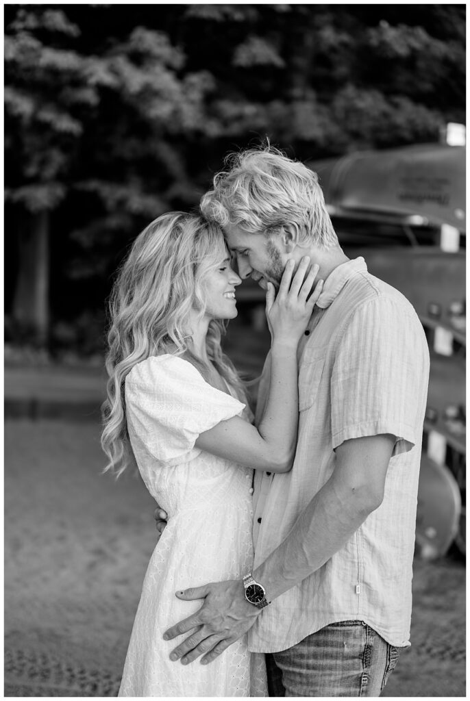 man and woman lean close as he holds her hips and she touches his face at Fish Park engagement session