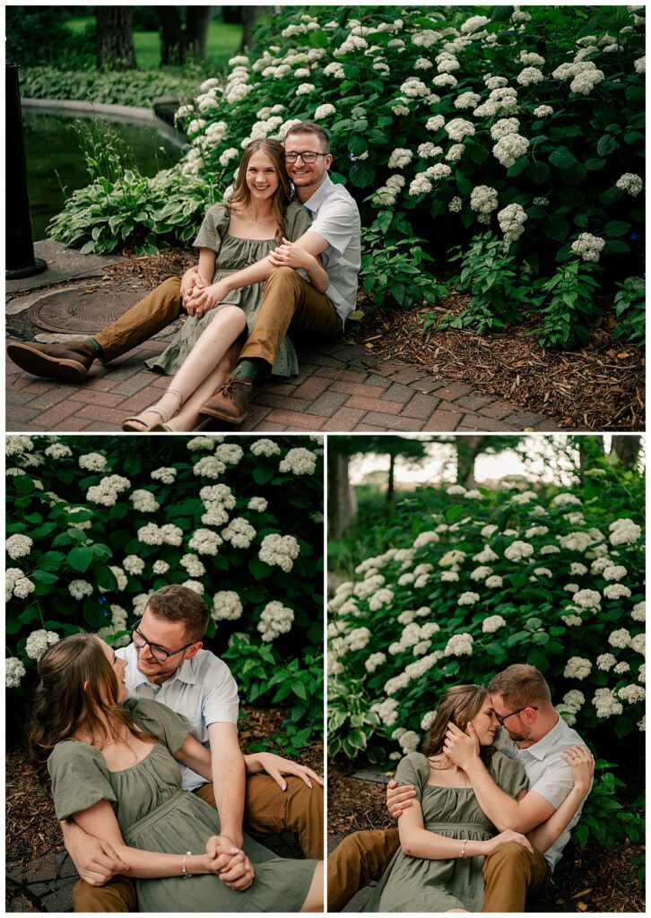 woman sits in man's lap in front of flowers by Minnesota wedding photographer