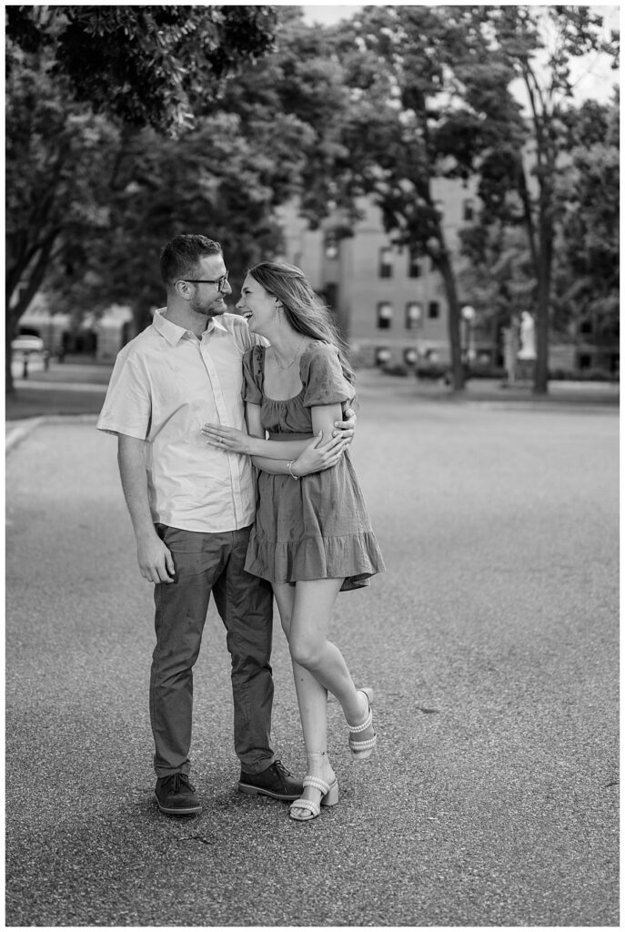 man and woman laugh together as his arm is around her by engagement at St. John's University