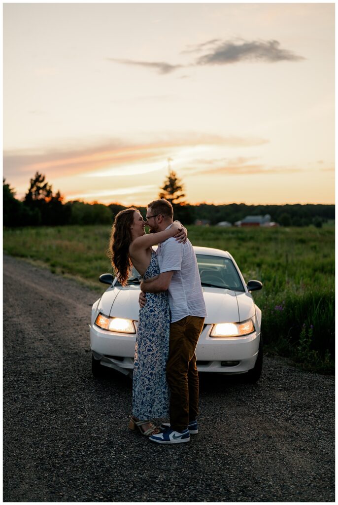 couple kisses in front of car during sunset by Minnesota wedding photographer