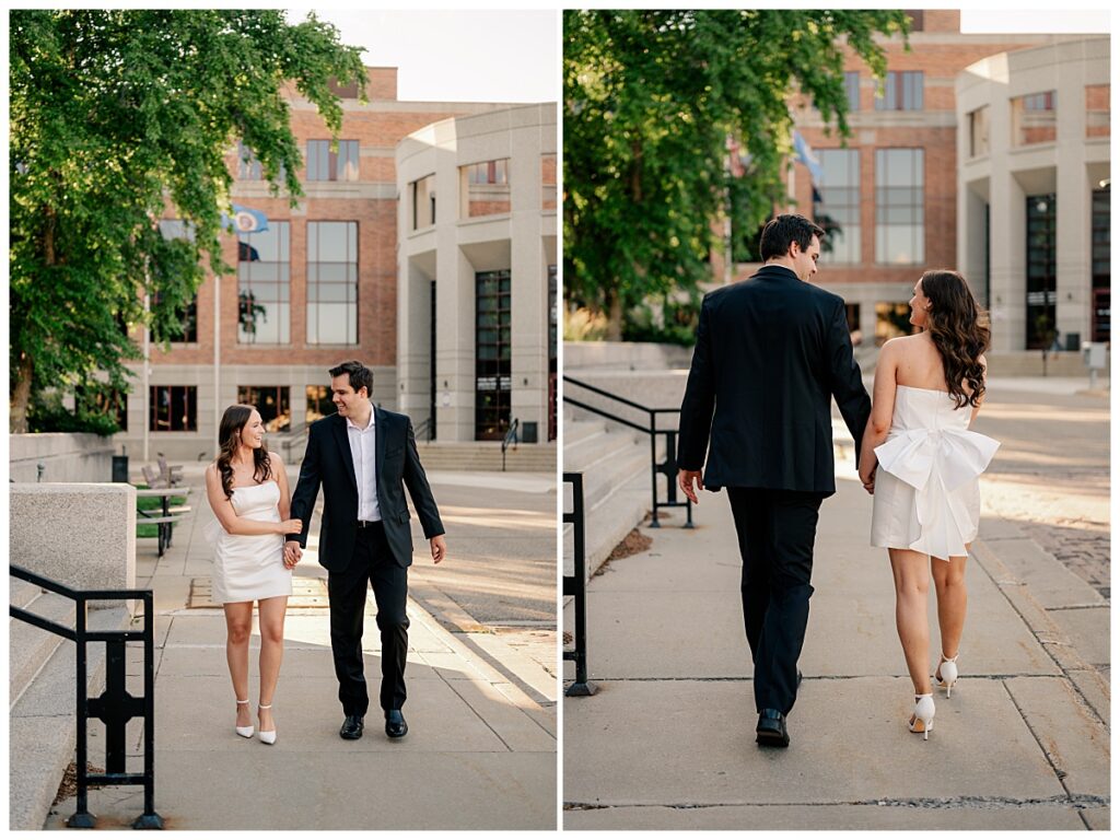 couple walks along sidewalk hand in hand at Downtown St. Cloud engagement session