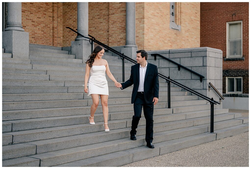 man helps bride-to-be down steps by Minnesota wedding photographer