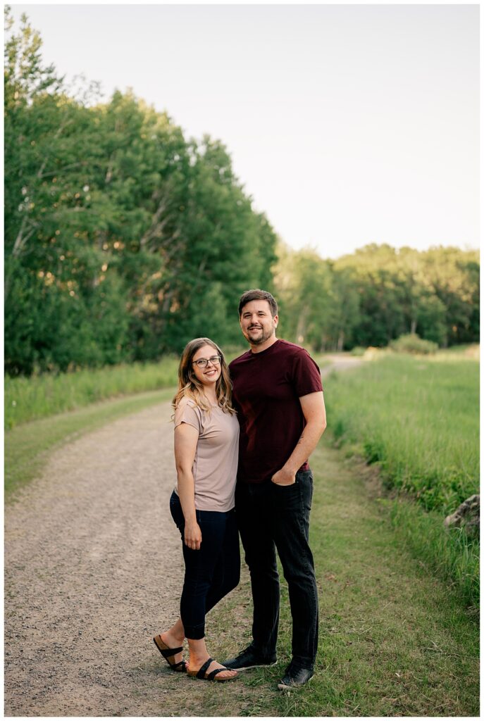 engaged couple smiles together along path by Rule Creative Co