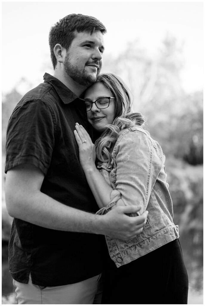 woman closes her eyes as she rests against man's chest by Minnesota wedding photographer