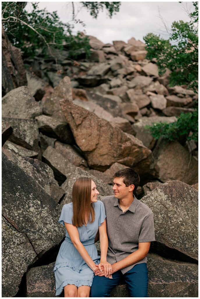 fiancés sit together on large rocks by Rule Creative Co