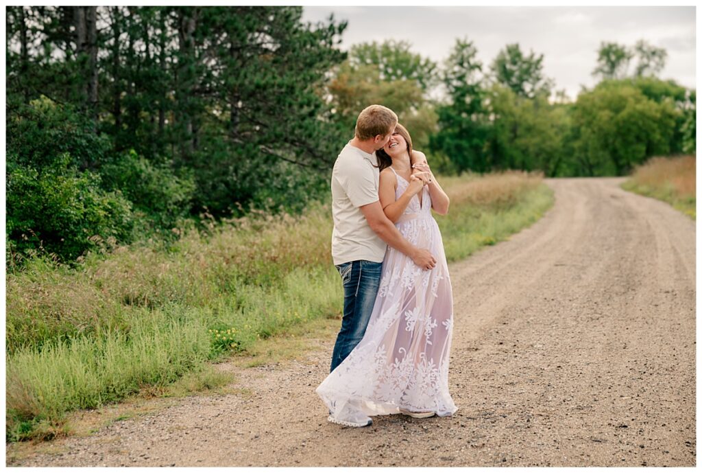 man wraps his arm around woman's shoulders from behind at St. John's Arboretum mini session