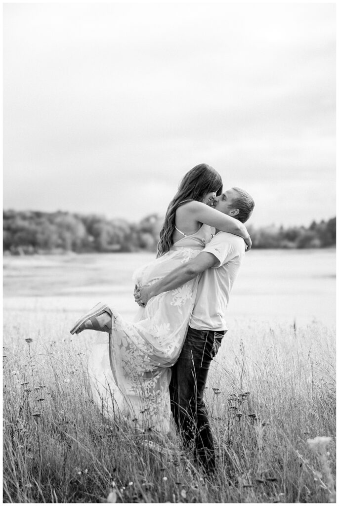 husband lifts wife as she kicks out legs and leans in to kiss him by Minnesota couples photographer