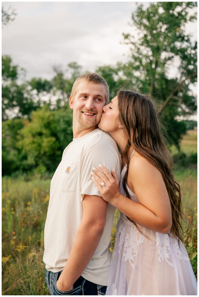 woman kisses man's cheek from behind by Rule Creative Co