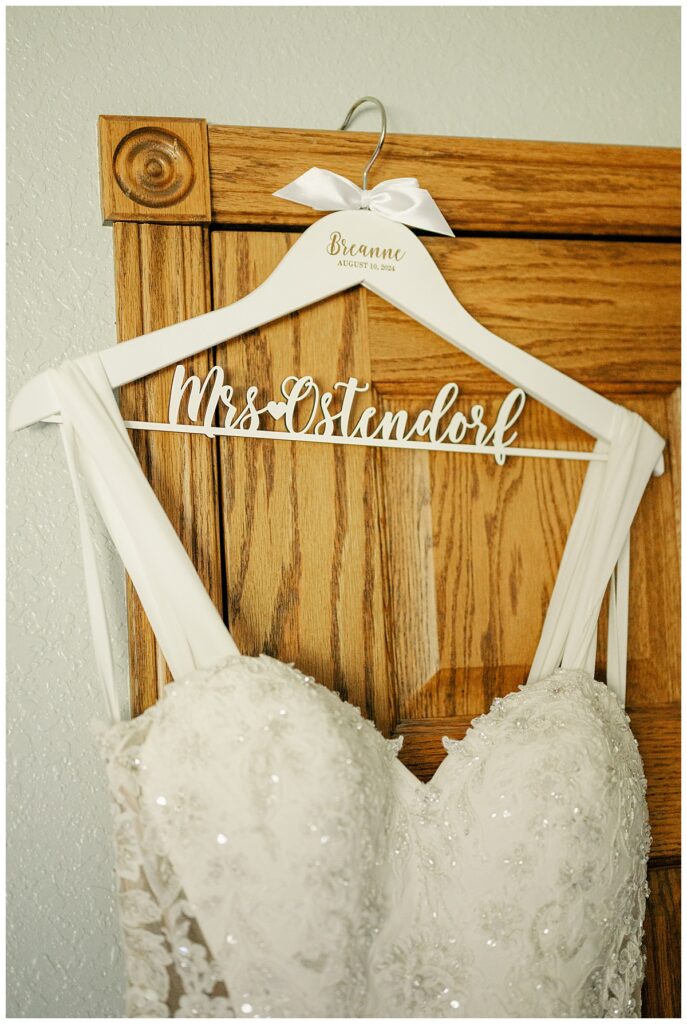 bridal gown hangs on door by Minnesota wedding photographer