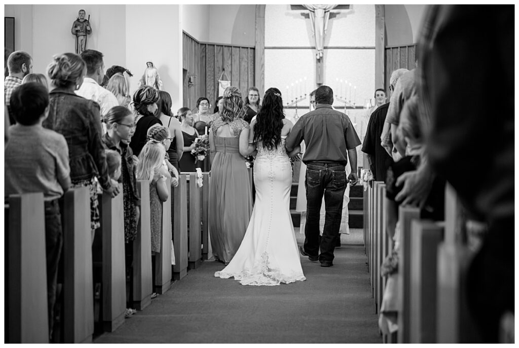 parents walk their daughter down the aisle at her late summer Central Minnesota wedding