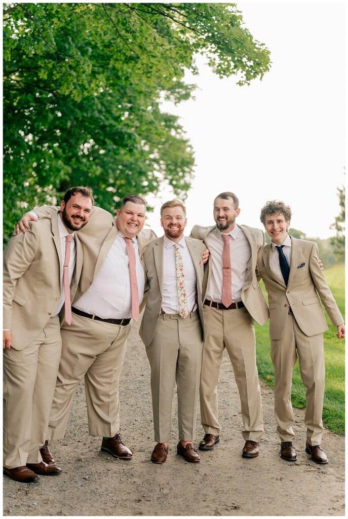 groomsmen wrap around around each other and laugh together by Rule Creative Co