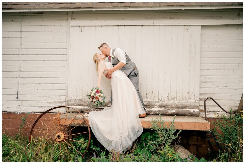 man dips woman and kisses her by Minnesota wedding photographer