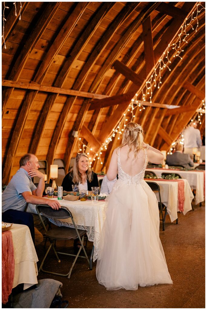 bride talks to guests at reception by Minnesota wedding photographer