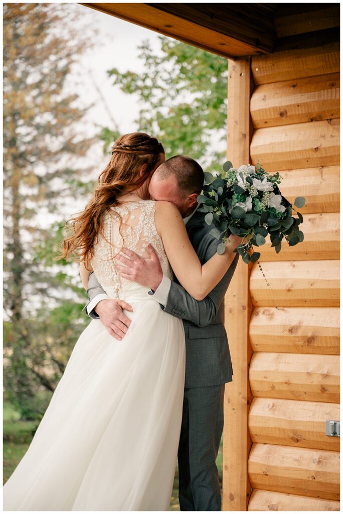 man buries face on woman's shoulder by Minnesota wedding photographer