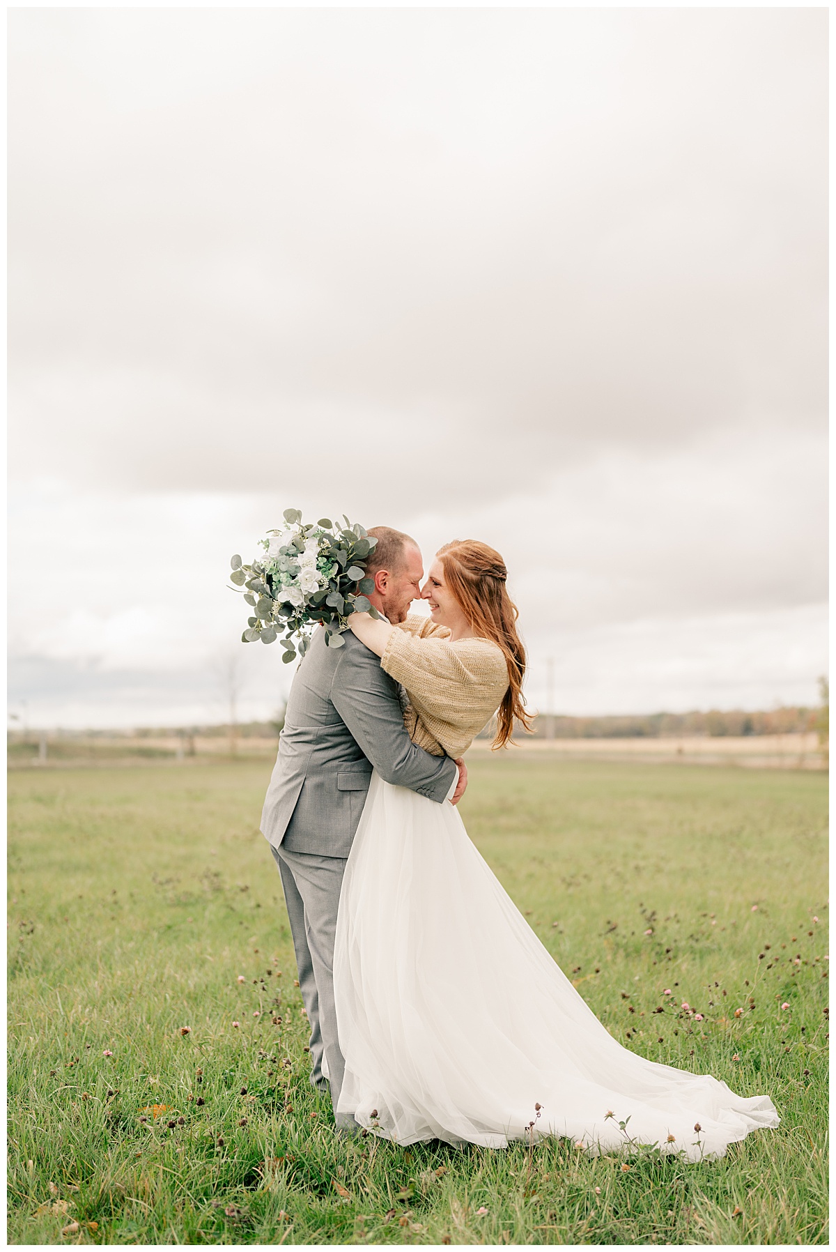 newlyweds hug in a field learning how to plan a destination wedding 
