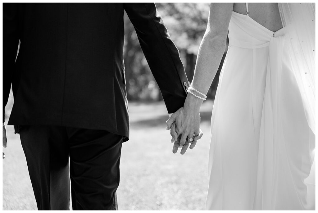 newlyweds hold hands by Minnesota wedding photographer