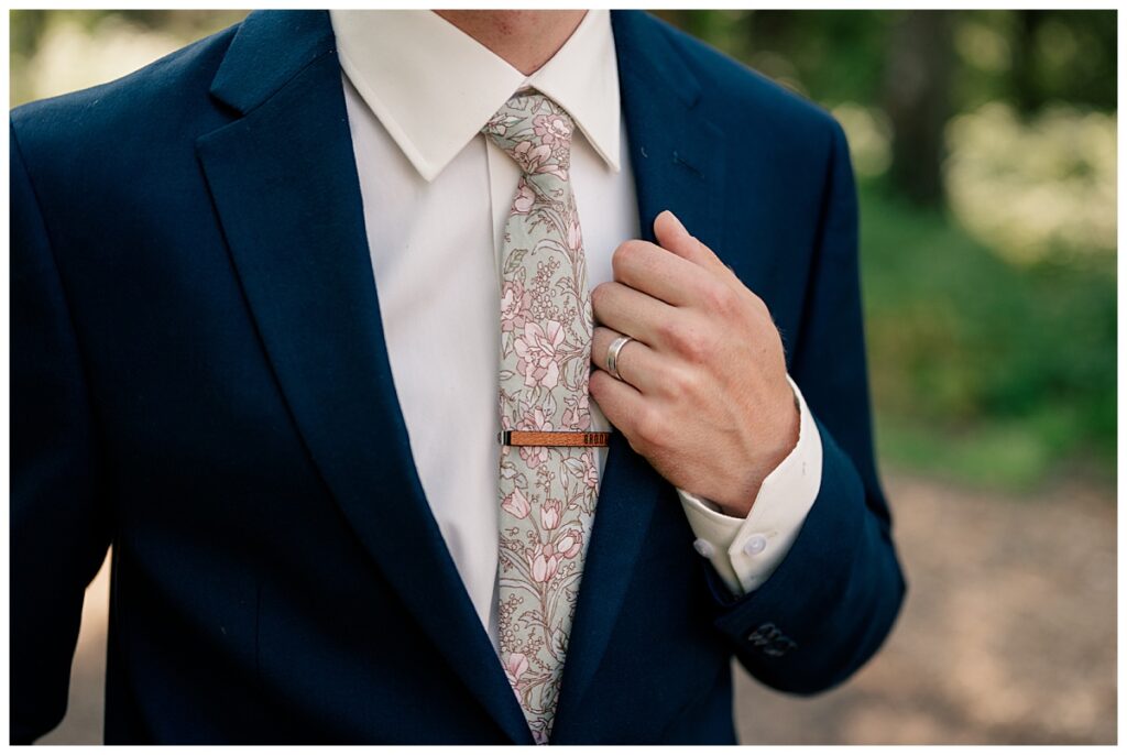 groom holds onto lapel of his coat by Rule Creative Co