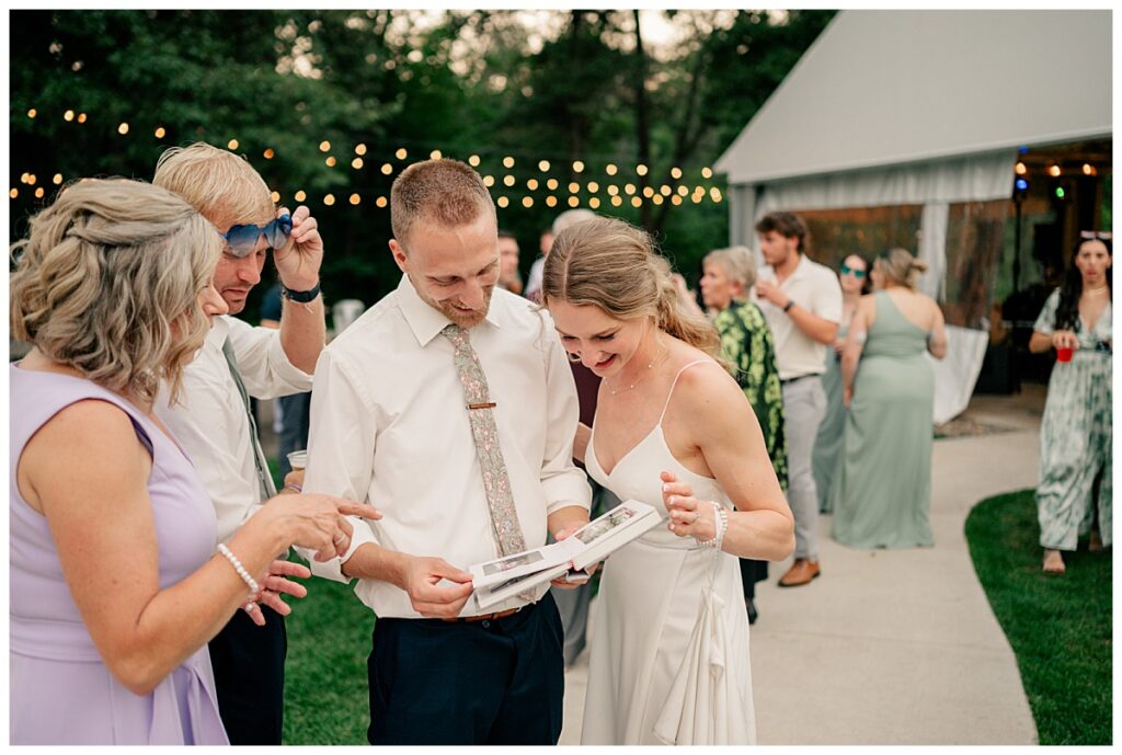 man and woman look through album at their Northern Oaks summer wedding