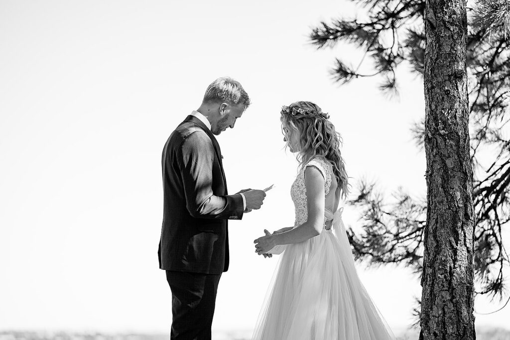 couples share love notes on hillside by Minnesota wedding photographer 