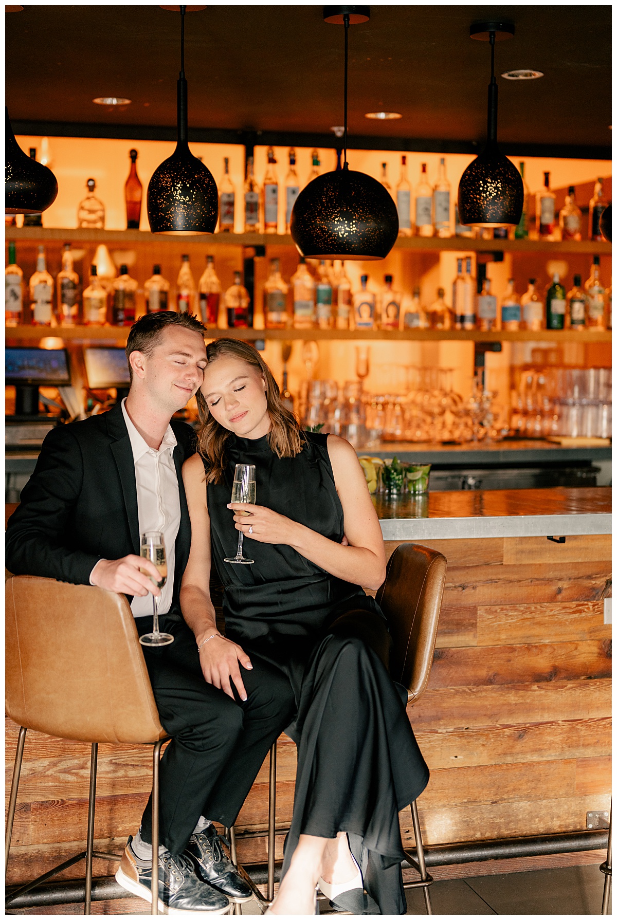 engaged couple embrace next to the bar by Minnesota wedding photographer 